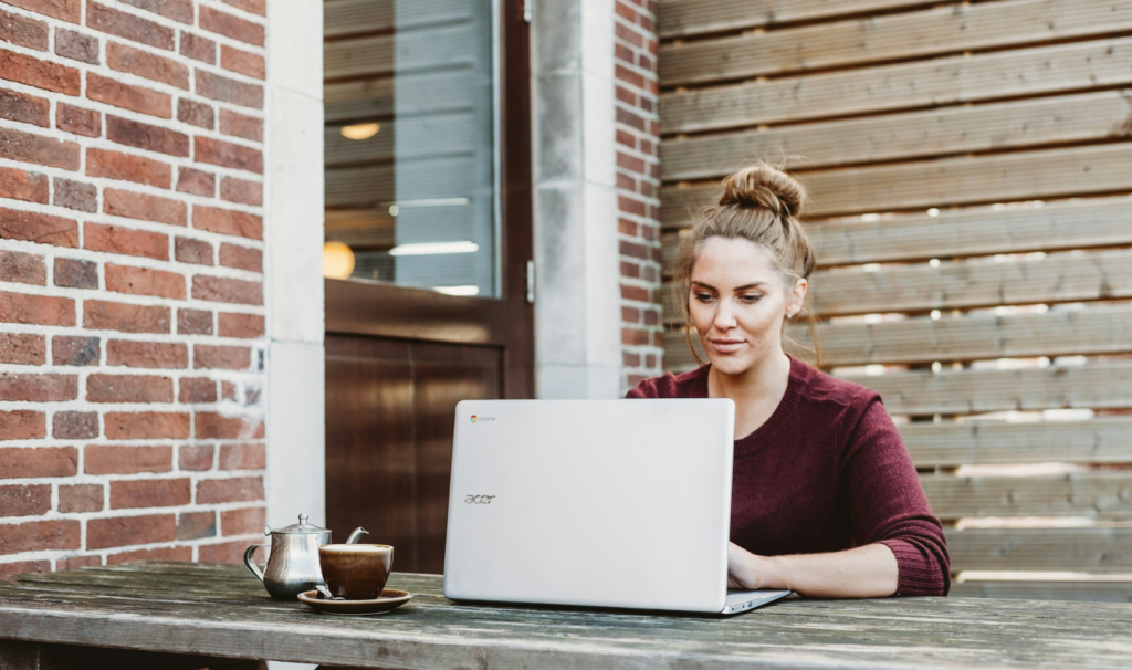 Woman working on a laptop outside.